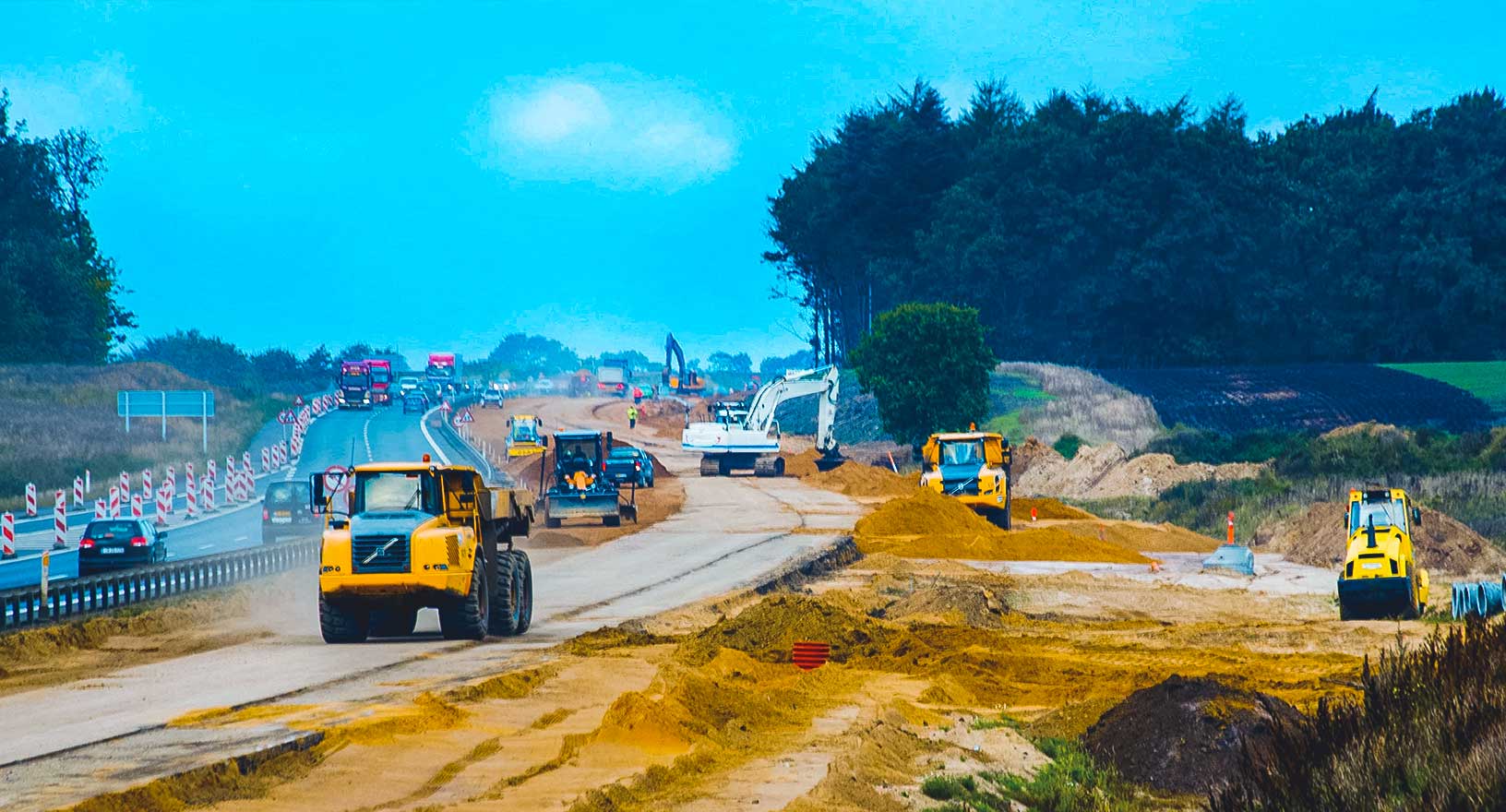 Eine Baustelle im Hintergrund. Unten auf dem Bild sind die Symbole für Baumaschinen zu sehen.